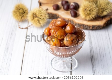 Chestnut dessert and chestnuts on a plate. Traditional delicious Turkish dessert; chestnut candies (Kestane Sekeri) Royalty-Free Stock Photo #2056102208