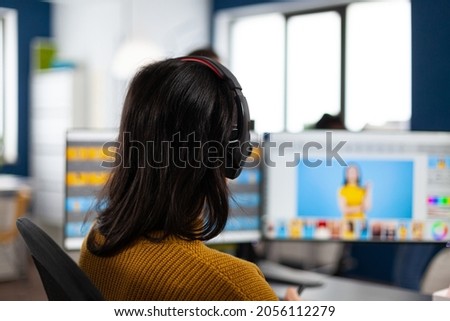 Creative photographer editor retouching photos of a client on performance PC with two displays setup. Woman retoucher working in editing software app sitting office holding stylus pen