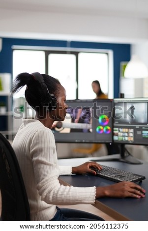 Black woman videographer developing project film montage sitting in creativity agency studio. Video editor creator in digital multimedia company editing movie with post production software