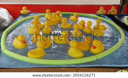 Yellow Plastic Ducks swimming in a pond at a State Fair Royalty-Free Stock Photo #2056126271