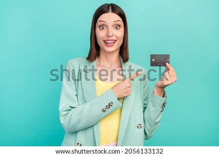Photo of impressed millennial brunette lady point card wear jacket isolated on cyan color background