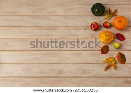Thanksgiving rustic decor with fall leaves, yellow, red and green pumpkins on the white painted wooden table, copy space