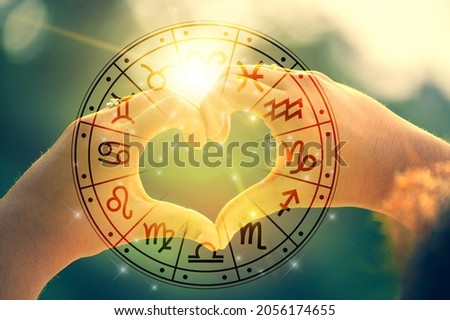 The hands of women and men are the heart shape with the sun light passing through the hands have astrological symbols Royalty-Free Stock Photo #2056174655