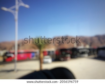 Defocused abstract background of the view in the bus window is cars and buses parked under the hill