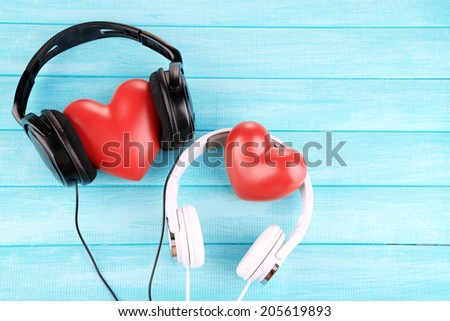 Headphones and hearts on wooden background