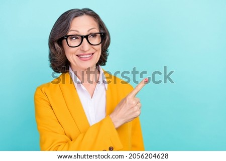 Photo of happy retired pensioner old woman point finger empty space smile news isolated on teal color background