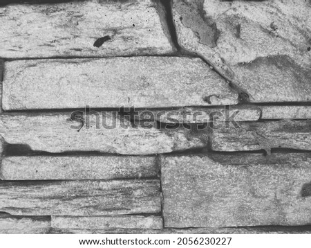 Masonry of long narrow stones or wall cladding with artificial stone imitating natural material.