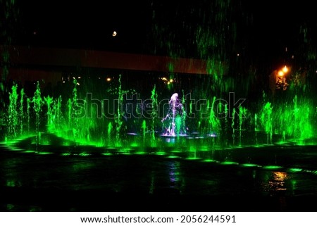 Green jets of the fountain at night. Background