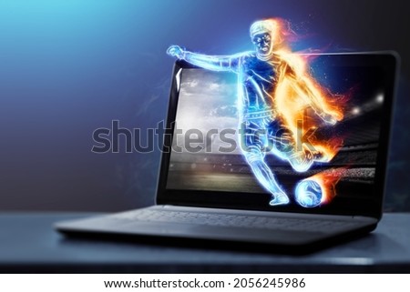 A hologram of a soccer player running out of a notebook, laptop screen. The concept of sports betting, football, gambling, online broadcast of football