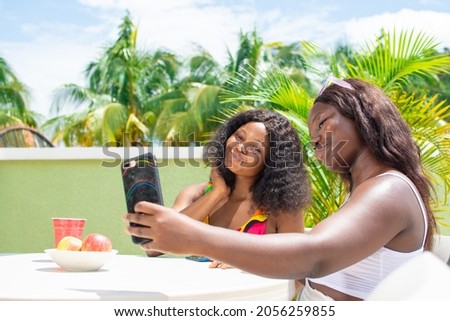 african girl and her friend taking pictures with her phone