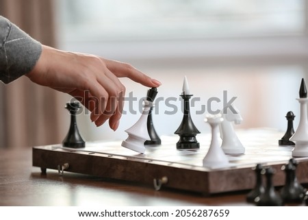 Young woman playing chess at home