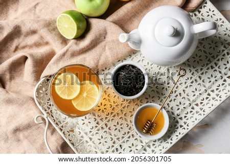 Composition with cup of hot healthy tea on light background