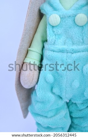 Cute Handmade textile bunny toy in beautiful green or mint coloured overall and sweater. Decorated with a handmade mint bow.
The background is white. 