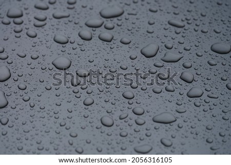 Closeup of raindrops on dark glass background