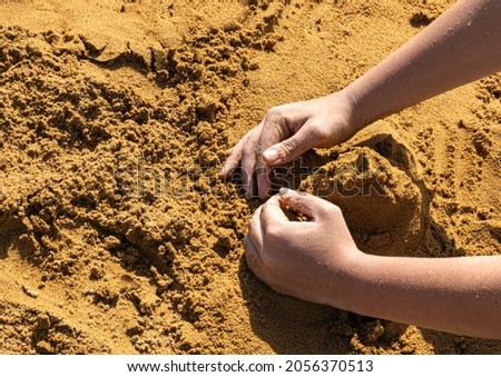 the hands of a sand castle builder. advertising picture. outdoor recreation. working with a sand figure. the child's hands create a sculpture.