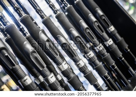 fishing rods of different construction and purpose on the counter of the store. Background of fishing rods