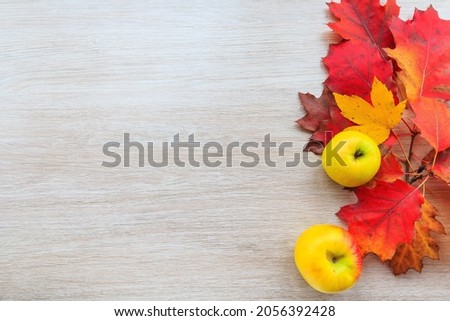Autumn decor from leaves and yellow apple on a wooden background. Flat lay autumn composition with copy space.