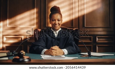Cinematic Court of Law Trial: Portrait of Impartial Smiling Female Judge Looking at Camera. Wise, Incorruptible, Fair Justice Doing Her Job Professionally, Sentencing Criminals and Protecting Innocent Royalty-Free Stock Photo #2056414439