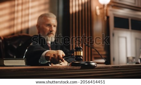 Court of Law and Justice Trial Session: Imparcial Honorable Judge Pronouncing Sentence, striking Gavel. Focus on Mallet, Hammer. Cinematic Shot of Dramatic Not Guilty Verdict. Royalty-Free Stock Photo #2056414451