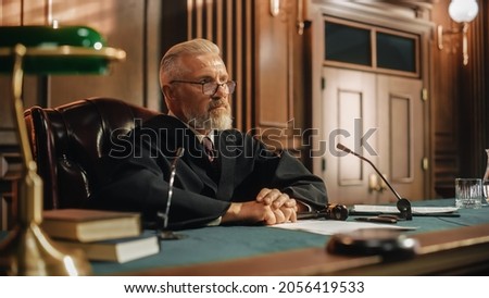Court of Law and Justice Trial: Portrait of Impartial Male Judge Listening To the Pleaded Case. Unbiased Decision after Hearing Arguments. Deliberation on Guilty, Not Guilty Verdict Royalty-Free Stock Photo #2056419533