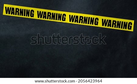 Yellow caution tape stripe with words warning. Concept of danger, security and protection