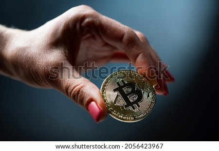 Female hand holding golden bitcoin virtual currency coin. Digital cyberspace money of future and symbol of mining and blockchain