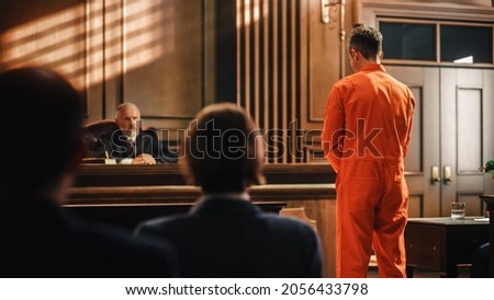 Court of Law and Justice Trial Proceedings: Law Offender in Orange Jumpsuit is Questioned and Giving Testimony to Judge, Jury. Criminal Denying Charges, Pleading, Inmate Denied Parole. Royalty-Free Stock Photo #2056433798