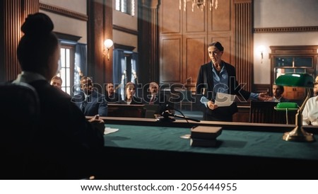 Court of Justice and Law Trial: Female Public Defender Presenting Case, Making Passionate Speech to Judge, Jury. Multiethnic Attorney Lawyer Protecting Client's Innocents with Supportive Evidence. Royalty-Free Stock Photo #2056444955