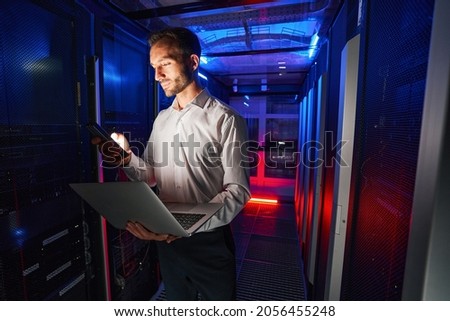 IT specialist using security appliance and laptop for server administration Royalty-Free Stock Photo #2056455248