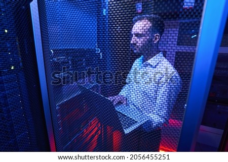 Professional system administrator maintaining data security in colocation center Royalty-Free Stock Photo #2056455251