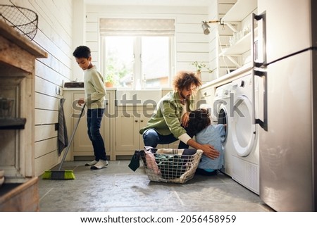Two boys helping father with household chores Royalty-Free Stock Photo #2056458959