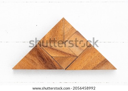 Wood tangram puzzle in triangle shape on white wood background