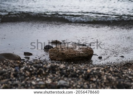 the stone lies on the beach and is washed by the waves, close-up.