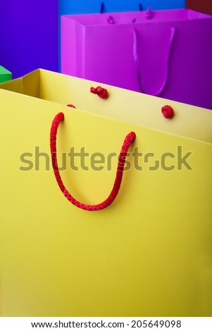 Colorful paper shopping bags with copy space. Yellow, violet, red, blue, pink and green shopping bags.