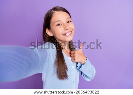 Photo of funky brunette small girl do selfie show thumb up wear blue shirt isolated on violet color background