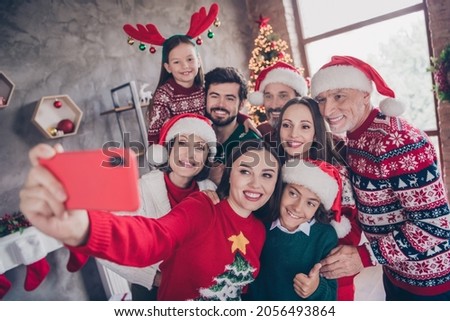 Photo portrait big family taking selfie smiling wearing festive xmas outfit in decorated apartment