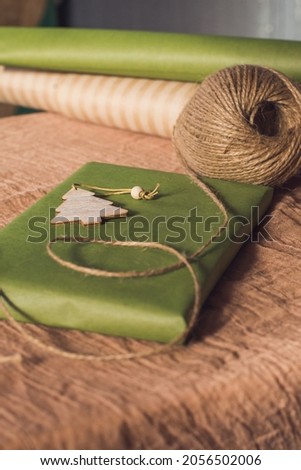 Christmas gift in green kravtovoy packaging. Gift wrapping. Christmas shopping