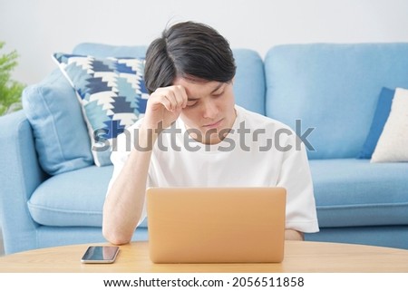 Asian man using the laptop in the room
