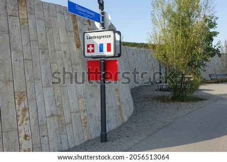 Swiss French border crossing with street sign of Elsässerrheinweg on bike path at the western Rhine shore, St. Johann, Basel, Switzerland and Saint Louis, Haut Rhin, Alsace, Grand Est, France