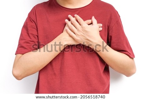 a young man hands holds his left chest, chest pain concept from Myocarditis or pericarditis caused by immune system,bacteria or viruses infection ,vaccination  Royalty-Free Stock Photo #2056518740