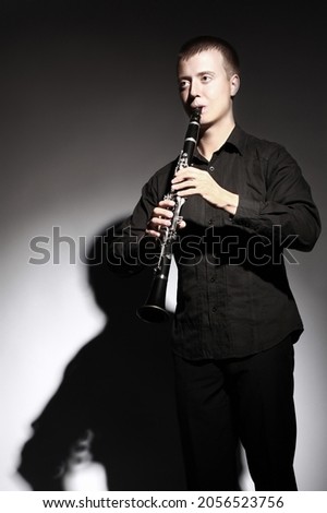 Clarinet player classical musician portrait. Clarinetist playing woodwind musical instrument