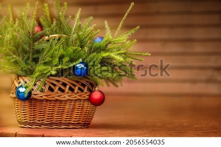 Basket with fir branches and Christmas ornaments