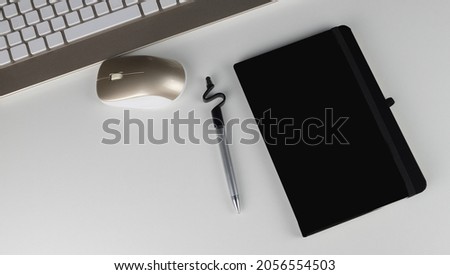 Stock photography of stylized white office table with blank notepad and pen and keyboard and mouse