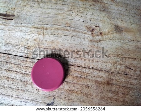 Photo of a red jar lid on a wooden background