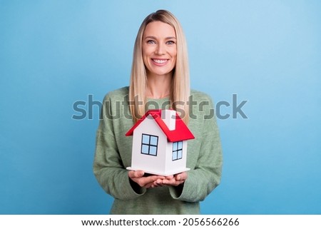 Photo of cheerful young girl good mood house relocation settlement isolated over blue color background
