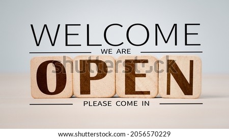 After a coronavirus lockdown quarantine, welcome we're open vintage black retro sign on a wood blog for a cafe. Small business owner, food and beverage, business reopening idea
