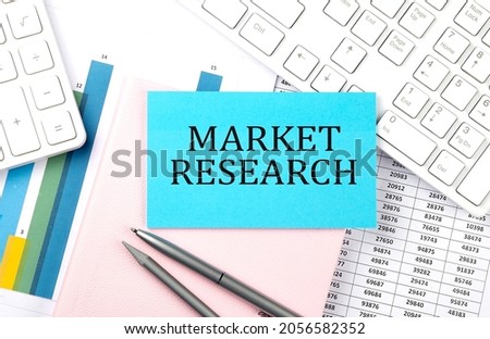 MARKET RESEARCH text on blue sticker on chart with calculator and keyboard,Business