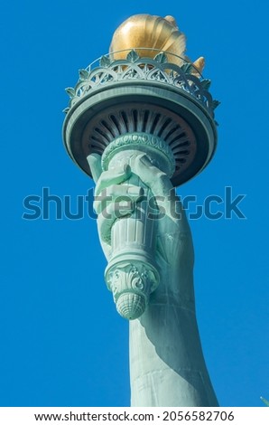 The hand torch of Statue of Liberty against blue sky in New York City . United States.