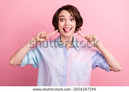 Photo portrait amazed woman cheerful fooling showing tongue pointing fingers isolated pastel pink color background