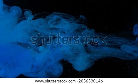 Awesome abstract background. Beautiful wallpaper for your desktop. Blue cloud of ink on a black background. Drops of blue ink in water. Blue watercolor paints in water on a black background.
